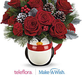 Red roses arranged in a penguin-shaped mug with pinecones and evergreen accents