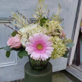 Pink gerbera daisy and roses in a glass vase