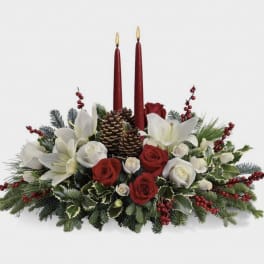 Holiday centerpiece with red candles, white lilies, and red and white roses