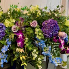Large mixed floral spray with purple, yellow, blue, and pink blooms