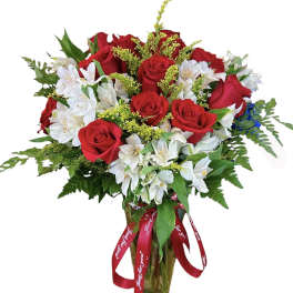 Bouquet of red roses and white alstroemeria in a glass vase