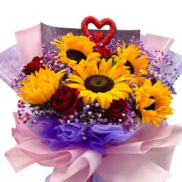 Bouquet of sunflowers and red roses with pink and purple wrapping