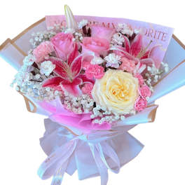 Bouquet of pink and cream roses with lilies and small white filler flowers