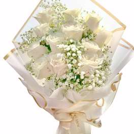 Bouquet of white roses and baby's breath wrapped in cream paper