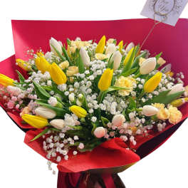 Bouquet of yellow and white tulips with baby's breath in red wrapping