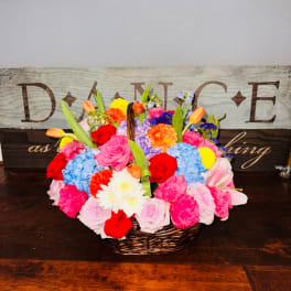 Colorful mixed flower basket arrangement in a wicker basket