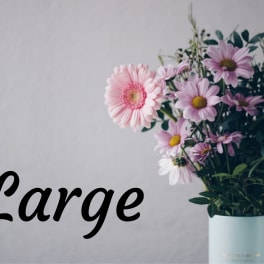 Large bouquet of pink and lavender daisies in a pale blue vase