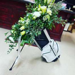 Large white floral spray on a stand with a white backpack attached