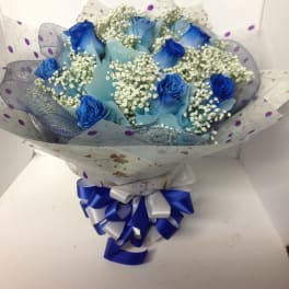 Blue roses with baby's breath in wrapped bouquet