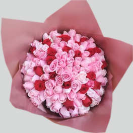 Bouquet of pink and red roses wrapped in pink paper