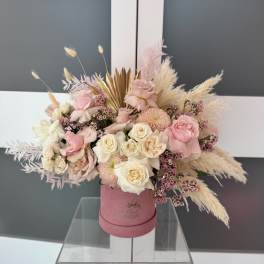 Pink and white rose arrangement in a pink hat box with dried pampas grass