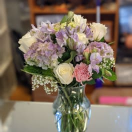 Bouquet of white and lavender flowers in a clear glass vase