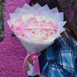 Pink and white rose bouquet with a birthday ribbon