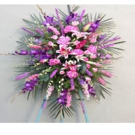 Large pink and purple floral standing spray with lilies and carnations