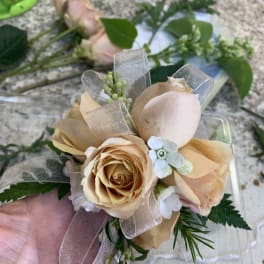 Small bouquet of peach roses with ribbon and greenery