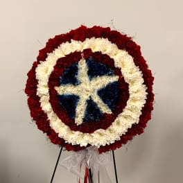 Round floral wreath in red, white, and blue on a stand