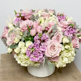 Pink and white rose arrangement in a white vase