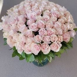 Large bouquet of pale pink roses in a glass vase