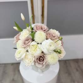 Bouquet of blush and white roses with round white blooms in a vase
