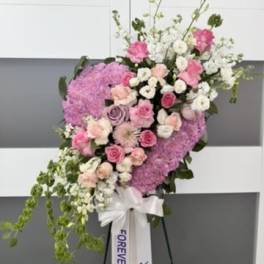 Standing floral spray with pink and white flowers on an easel