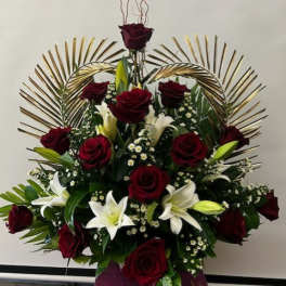 Red roses and white lilies arranged in a tall display with gold fan accents