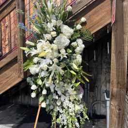 Tall white floral standing spray on an easel