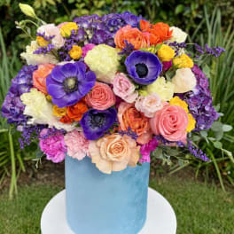 Colorful mixed bouquet in a light blue cylindrical vase