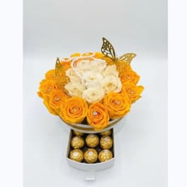 Yellow and white rose arrangement in a round box with chocolates below