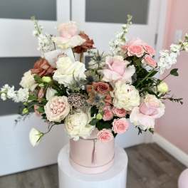 Pink and white roses arranged in a round hatbox