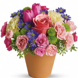 Pink and purple mixed bouquet in a tan cone vase