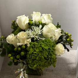White roses and green hydrangea in a compact bouquet
