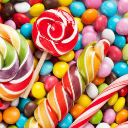 Assorted colorful lollipops on a bed of candy-coated chocolates