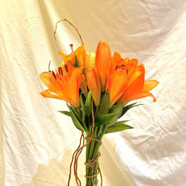 Orange lilies and pink roses arranged in a tall vase