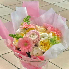 Pink and white bouquet with gerbera daisies and ranunculus in clear wrap