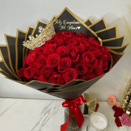 Bouquet of red roses with a jeweled crown and black-and-gold wrapping