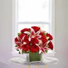 Red roses and pink lilies in a square glass vase