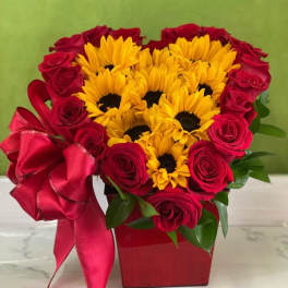 Heart-shaped bouquet of red roses and yellow sunflowers in a red box