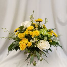 Yellow and white rose arrangement in a white vase