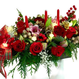 Red rose centerpiece with candles, pinecones, and plaid ribbon