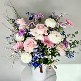 Mixed bouquet of pink and white flowers in a white vase