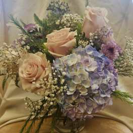 Bouquet of pale pink roses and lavender hydrangea in a glass vase