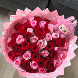 Bouquet of red and pink roses with a pink plush toy