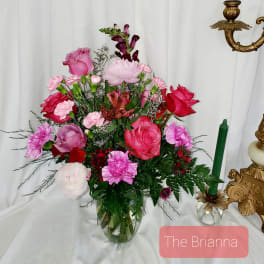 Pink and red mixed flower arrangement in a glass vase