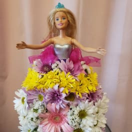 Doll in a dress covered with pastel daisies and ribbon