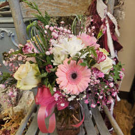 Pink and white mixed bouquet in a glass vase with a ribbon