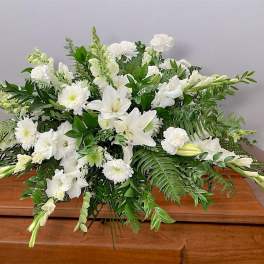 White floral spray on a wooden casket