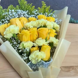 Yellow roses and pale yellow carnations in cream wrapping