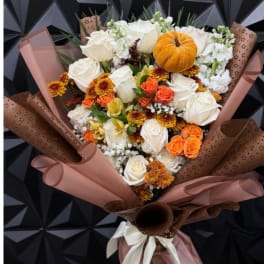 Bouquet of white and orange flowers with a small pumpkin accent