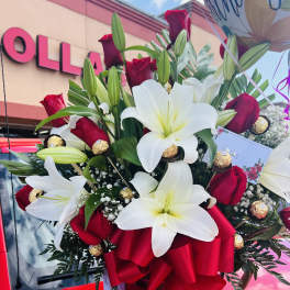 Bouquet of white lilies and red roses with a red ribbon