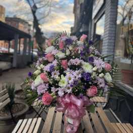Large bouquet of pink and purple flowers tied with a pink ribbon